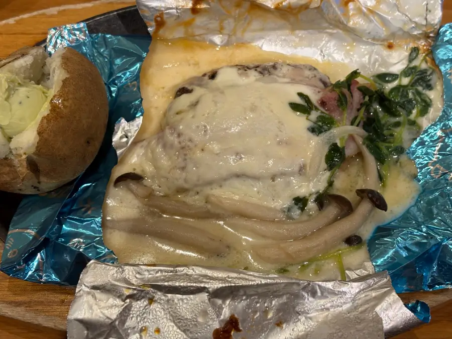 ハチワレのクリームソース包み焼きハンバーグ開封直後。チーズがとろけ、ベーコンときのこ、豆苗がソースに絡む。