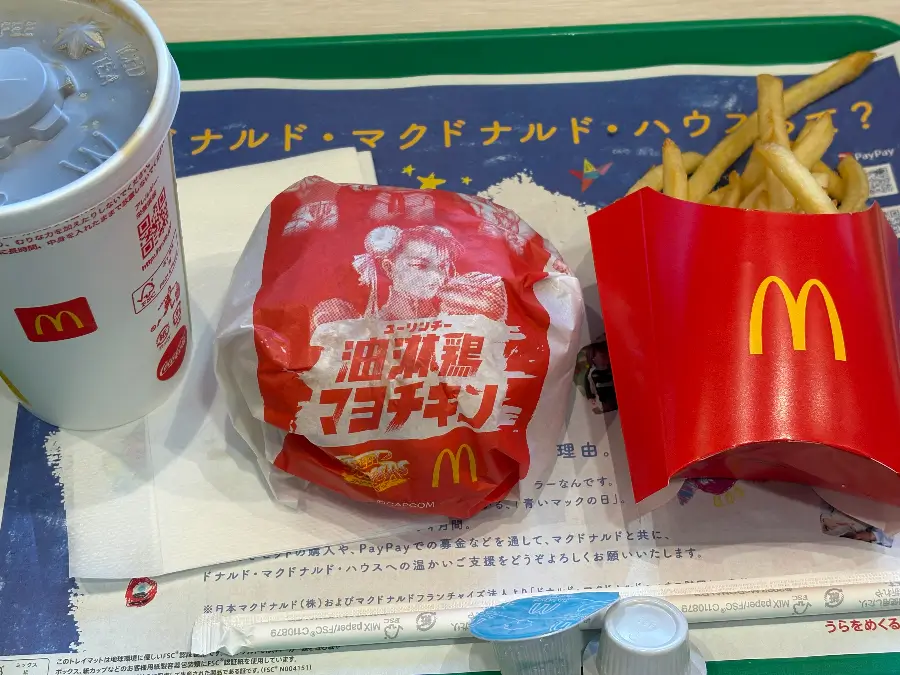 マクドナルドの「油淋鶏マヨチキン」セット。赤いチュン・リーのパッケージのバーガー、ポテト、アイスコーヒーがトレーに並んでいる。