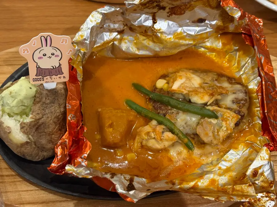 うさぎのバターチキンカレー包み焼きハンバーグ開封直後。チーズがとろけ、チキンやかぼちゃ、インゲンがソースに絡む。